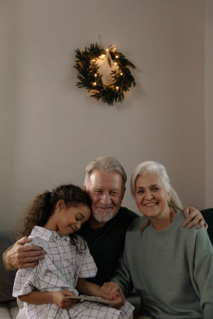 pexels-photo-6158671-6158671 Grandparents and granddaughter hugging with a festive wreath in the background